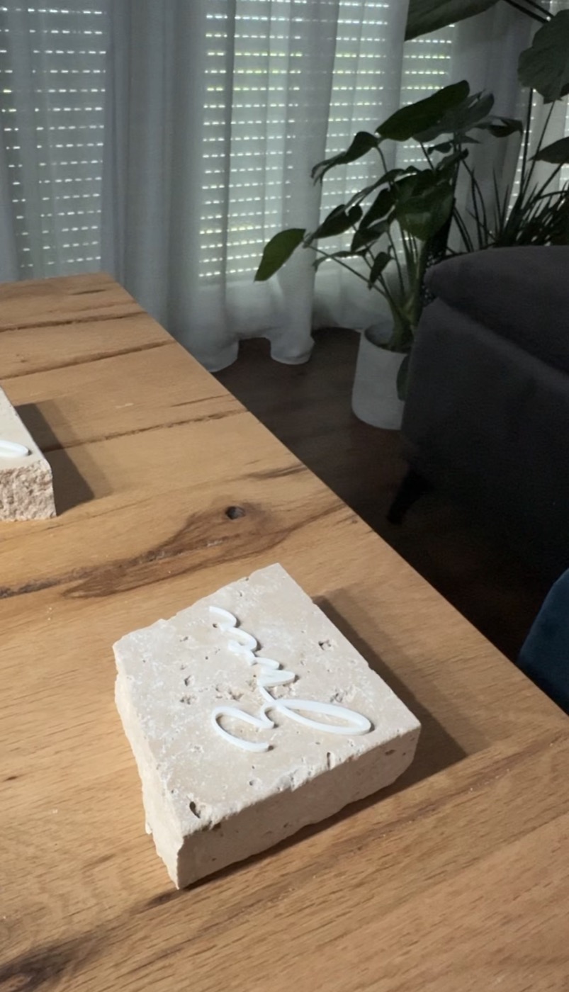 3D-gedruckter Schriftzug wird auf den Travertinstein geklebt